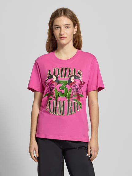 Frauenmodel trägt T-Shirt mit Label-Print von adidas Sportswear in Pink, reine Baumwolle, Regular Fit, Rundhalsausschnitt, Ganzkörperansicht von vorne.