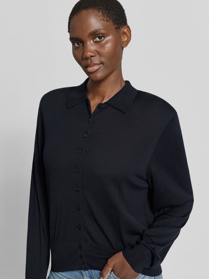 Frauenmodel trägt Regular Fit Cardigan aus reiner Wolle Modell 'BOSTON' von ba&sh in Dunkelblau, Umlegekragen, Nahaufnahme Oberkörper.