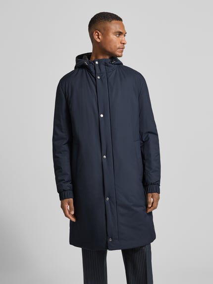 Männermodel draagt Regular Fit lange jas met capuchon en drukknopen, effen kleuren, waterafstotend, BOSS; Ganzkörperansicht van voren.