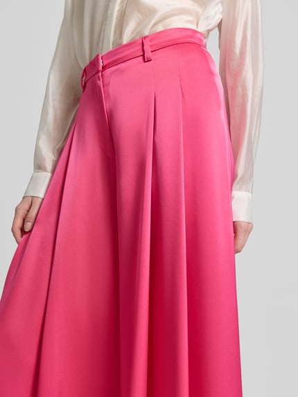 Frauenmodel trägt Stoffhose mit Biesen und Eingrifftaschen von Marc Cain in Pink, Baumwoll-Mix mit Stretch-Anteil, Wide-Fit, Nahaufnahme Oberkörper.
