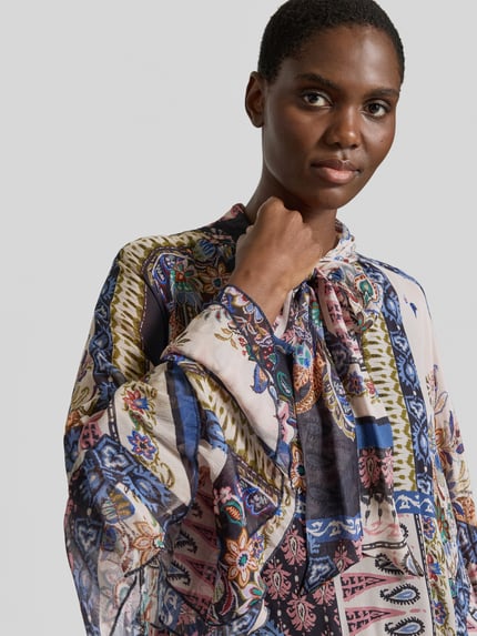 Frauenmodel trägt Schluppenbluse aus Viskose mit Volants von Milano Italy, bunte Muster in Blau, Grün und Rosa, Nahaufnahme Oberkörper. Damen Schluppenbluse, reine Viskose, gerader Schnitt, Schluppe, Volants, Kimonoärmel, Rückenlänge 43 cm bei Größe 36, Ärmellänge 64 cm bei Größe 36.
