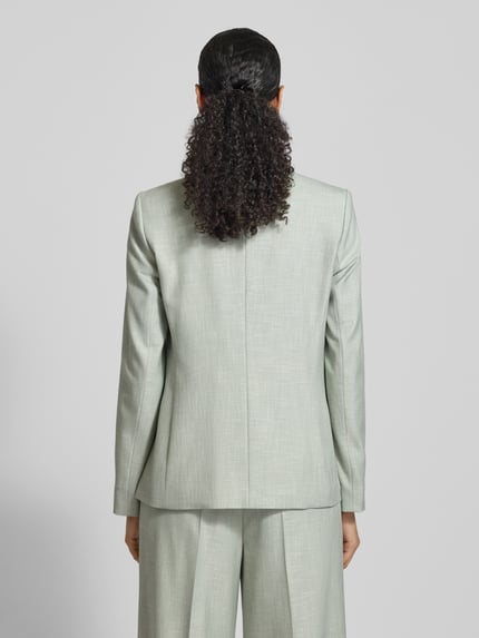 Frauenmodel trägt Regular Fit Blazer aus Viskose-Mix mit Reverskragen von Comma, hellgrün, Pattentaschen, 2-Knopfleiste, Rückenlänge 69 cm, Brustweite 43 cm, Ärmellänge 62 cm, Ganzkörperansicht Rückansicht.