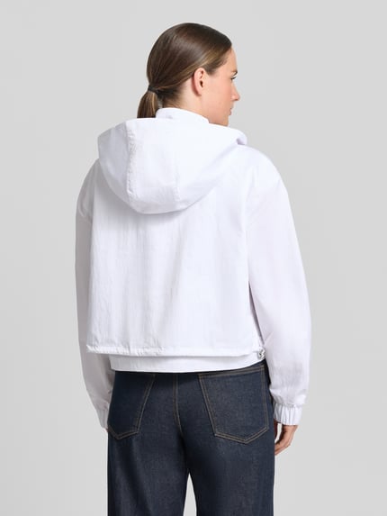 Frauenmodel trägt Jacke mit Stehkragen und verdecktem Reißverschluss von monari, weiß, strukturierte Oberfläche, Reißverschlusstaschen, Regular-Fit, Rückenlänge 49 cm, Schulterbreite 55 cm, Brustweite 57 cm, Ärmellänge 58 cm, Ganzkörperansicht Rückansicht.