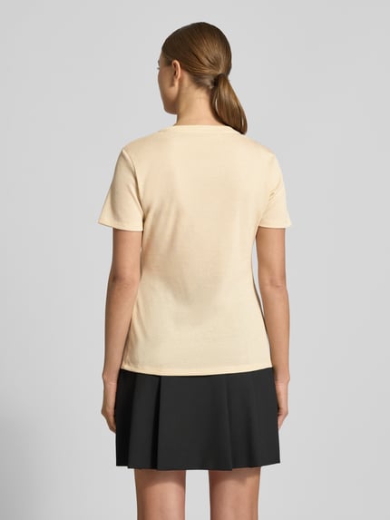 Frauenmodel trägt Regular Fit T-Shirt aus Viskose-Mix von LIU JO SPORT, cremefarben mit Glitzer-Optik und Logo-Detail, Rückenlänge 60 cm, Ganzkörperansicht Rückansicht.