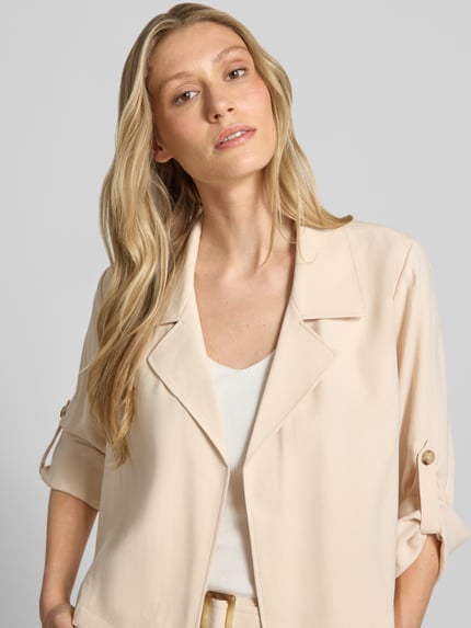 Frauenmodel trägt Slim Fit Kurzblazer aus Viskose-Mix von s.Oliver BLACK LABEL in Optik: Unifarben, Reverskragen, Langarm, Nahaufnahme Oberkörper.