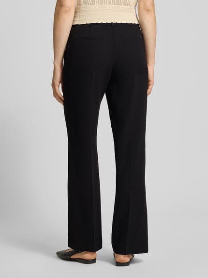 Vrouwenmodel draagt zwarte dames broek met persplooien, model 'LARA' van Samsøe Samsøe, regular fit, paspelzakken achter, bandwijdte maat S 39 cm, binnenbeenlengte maat S 85 cm, volledig lichaamsaanzicht achteraan.
