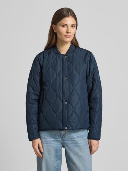 Vrouwenmodel draagt gewatteerd jack met opstaande kraag model 'FENYA 78' van Soyaconcept, regular fit, knoopsluiting, ruglengte maat S 62 cm, schouderbreedte 42 cm, borstwijdte 53 cm, mouwlengte 62 cm, donkerblauw met golvende doorgestikte naden, voorkant, close-up bovenlichaam.