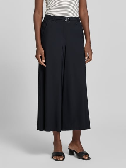 Frauenmodel trägt Hose in verkürzter Passform mit Gürtel Modell 'Pia' von MAC, schwarz, weites Bein, elastischer Bund, Material-Mix, Nahaufnahme Oberkörper.