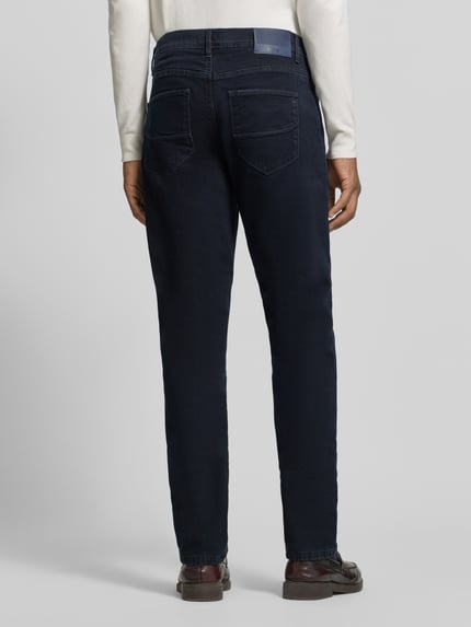 Männermodel trägt Straight Fit Jeans Modell 'Cadiz' von Brax im dunklen Denim-Look mit 5-Pocket-Design, Ganzkörperansicht Rückansicht.