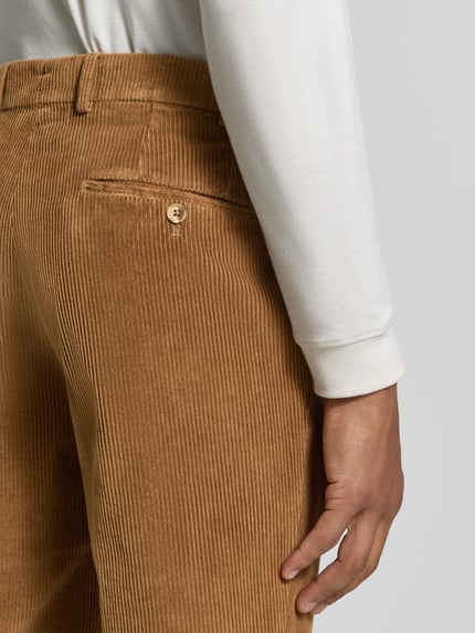 Männermodel trägt Regular Fit Cordhose mit seitlichen Eingrifftaschen von Hiltl, unifarben, Cordtextur, Detailaufnahme Rückansicht.