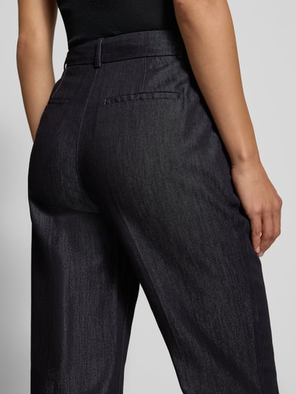 Frauenmodel trägt Hose in Denim-Optik mit Bügelfalten von Christian Berg Woman Selection, dunkles Blau, glatte Textur, Nahaufnahme Rückansicht. Baumwoll-Lyocell-Mix, Regular Fit, dezenter Glanz.