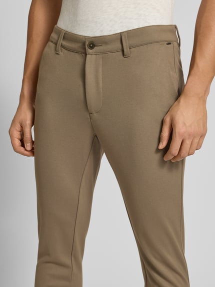 Mannenmodel draagt Slim Fit Chino uit Viscose-Mix model 'MARK' van Only & Sons, effen beige, zijzakken, detailopname voorkant.