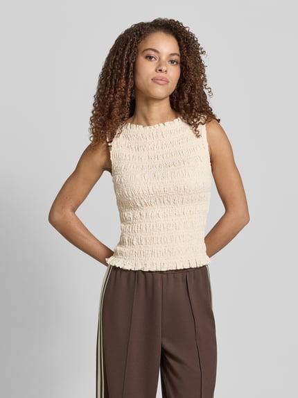 Modelka nosi Top mit Smok-Details und Rundhalsausschnitt von Jake*s Casual, mieszanka bawełny z dodatkiem streczu, dopasowany krój, okrągły dekolt, długość tyłu w rozmiarze 38: 51 cm, jasny odcień, marszczona tekstura, całkowity widok z przodu.