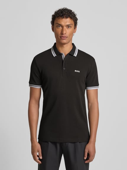 Männermodel draagt Regular Fit Poloshirt met labelstitching model 'Paddy' van BOSS, puur katoen, polokraag, knoopsluiting, ribboorden. Ganzkörperansicht van voren.