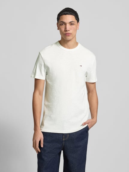 Männermodel trägt Regular Fit T-shirt aus puur katoen van Tommy Jeans, look: effen, logodetail, ronde hals, korte mouw, jersey, Ganzkörperansicht van voren.