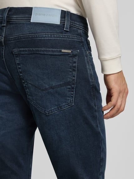 Männermodel trägt Straight Fit Jeans aus elastischem Baumwoll-Mix Modell 'Lyon' von Pierre Cardin, Dunkelblau mit 5-Pocket-Design, Detailaufnahme Rückansicht. Herren Jeans von Pierre Cardin, elastischer Baumwoll-Mix, Straight Fit, Modell 'Lyon', 5-Pocket-Design, Gürtelschlaufen, Knopf- und Reißverschluss, Bundweite bei Größe 32/32: 45 cm, Innenbeinlänge bei Größe 32/32: 83 cm.