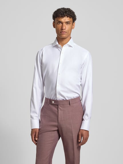 Männermodel trägt Regular Fit Businesshemd aus reiner Baumwolle Modell 'H-JOE-SP' von BOSS in Weiß, Ganzkörperansicht von vorne.