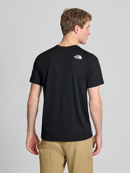 Männermodel trägt T-Shirt mit Logo und Rundhalsausschnitt von The North Face, regular fit, zwarte kleur, ruglengte maat M 69 cm, ganzkörperansicht rückansicht.