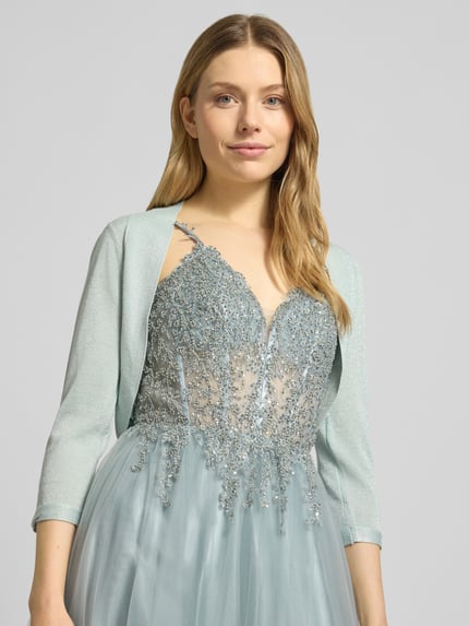 Vrouwenmodel draagt Regular Fit Bolero uit viscose-mix van Jake*s Cocktail, striklook, glittereffect, 3/4-mouw, lichtblauw, close-up bovenlichaam.