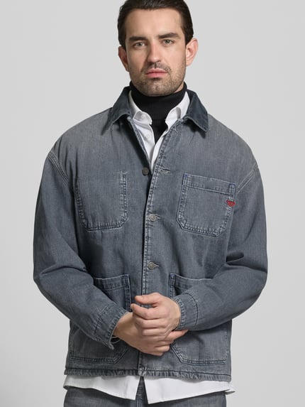 Männermodel trägt Regular Fit Hemdjacke in Denim-Optik von Diesel aus reiner Baumwolle, graublaue Farbe, AufgesetzteTaschen, Knopfleiste, Ganzkörperansicht von vorne.