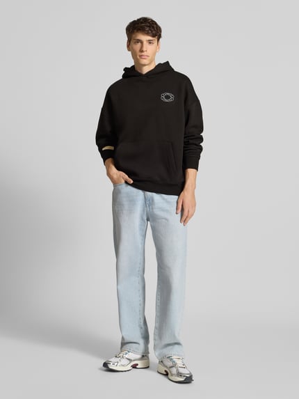 Mannelijk model draagt Hoodie met Kapuze van PROHIBITED in zwart, katoenmix, loose fit, met buidelzak en logo-detail, voorkant volledige lichaamsweergave.