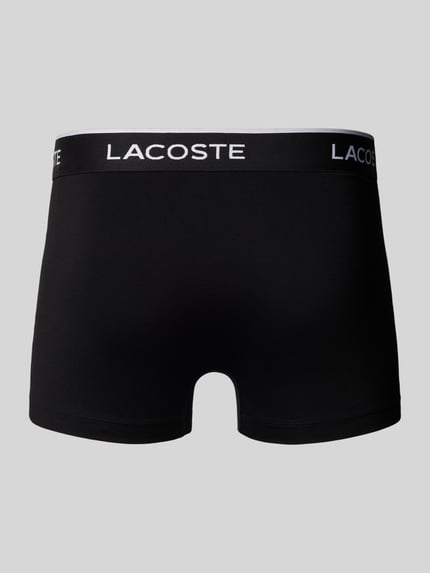 Produktfoto, schwarze Pant & Trunk aus Baumwoll-Mix im 5er-Pack von Lacoste vor grauem Hintergrund, weiße Schrift auf Bund. Herren Pant & Trunk von Lacoste
