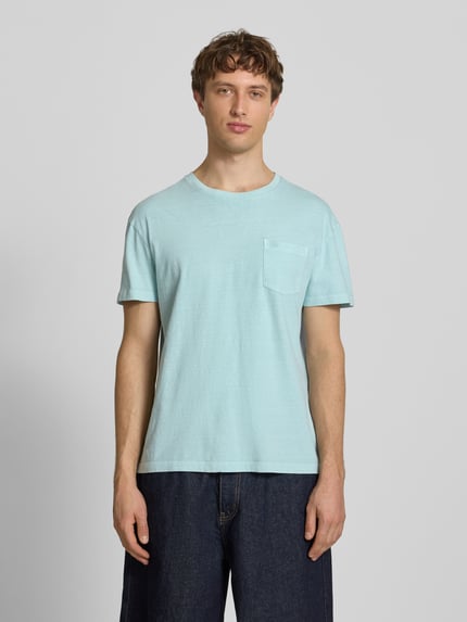 Mannenmodel draagt T-Shirt uit katoen-linnenmix met borstzak van Superdry in lichtblauw, regular fit, ronde hals, voorkant volledige lichaamsvoorstelling.