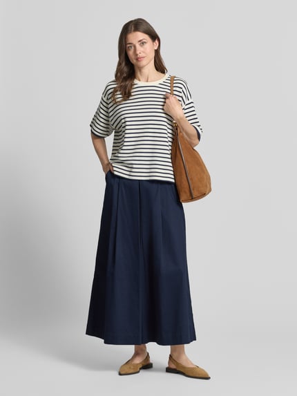 Frauenmodel trägt Wide Fit Stoffhose mit Bundfalten von Christian Berg Woman, dunkelblau, reine Baumwolle, Ganzkörperansicht von vorne.