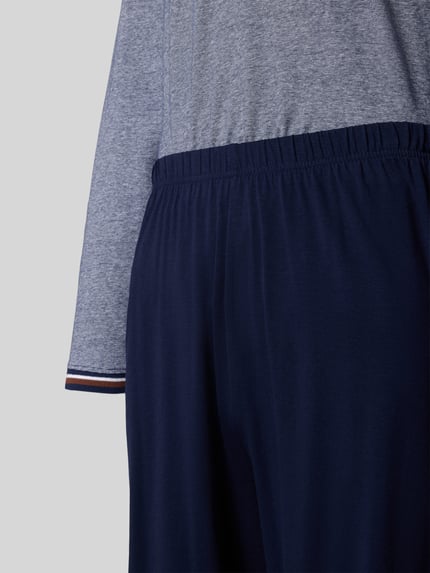 Männermodel trägt Pyjama mit Rundhalsausschnitt und Brusttasche von bugatti aus Baumwoll-Elasthan-Mix, Nahaufnahme Oberkörper und Hüfte.
