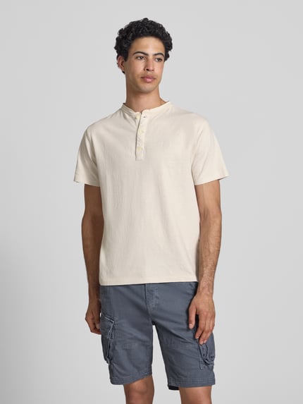 Männermodel trägt T-Shirt mit kurzer Knopfleiste von Superdry, Herren T-Shirt, Leinen-Baumwoll-Mix, Regular-Fit, Polokragen, Logo-Stitching, Rückenlänge bei Größe M 62 cm, Nahaufnahme Oberkörper.
