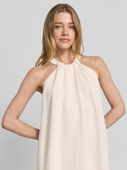 Vrouwenmodel draagt midi-jurk met linnen en viscose, loose fit, ronde hals met plooien, model 'Qelina' van Someday, viscosemix, nahaufnahme bovenlichaam.