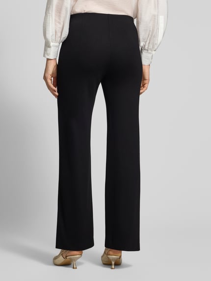 Frauenmodel trägt Stoffhose mit elastischem Bund von Marc Cain in Schwarz, Viskose-Mix mit Stretch, lockerer Schnitt, Ganzkörperansicht Rückansicht.