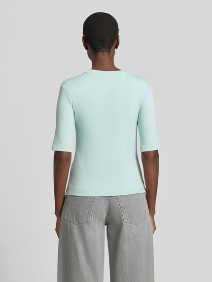 Frauenmodel trägt T-Shirt mit Rundhalsausschnitt von Christian Berg Woman, Damen T-Shirt aus Baumwoll-Elasthan-Mix in Slim-Fit, 1/2-Arm, Rückenlänge bei Größe S 53 cm, hellblaue Farbe, glatte Struktur, Ganzkörperansicht Rückansicht.