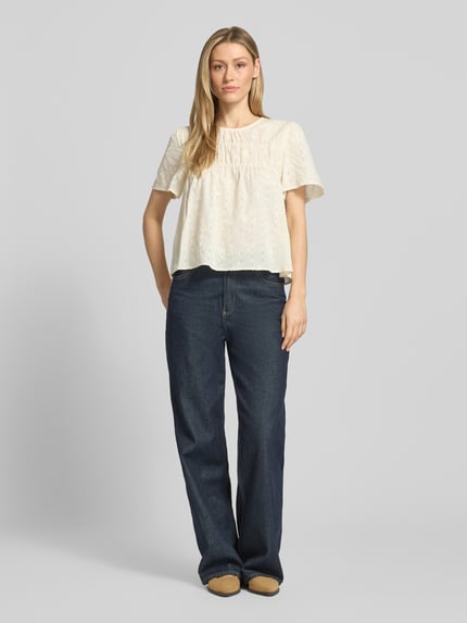 Frauenmodel trägt Blusenshirt mit Stitchings Modell 'LANA' von ICHI aus Baumwoll-Viskose-Mix, Regular-Fit, cremefarben, Ganzkörperansicht von vorne.