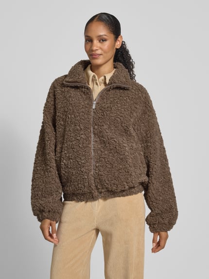 Frauenmodel trägt Jacke mit Stehkragen von JAKE*S STUDIO WOMAN in Braun, lockerer Schnitt, Reißverschluss, Eingrifftaschen, elastische Ärmelabschlüsse, Ganzkörperansicht von vorne.