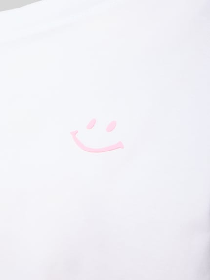Vrouwenmodel draagt Pyjama-Oberteil met Motiv-Print van Mey in wit met roze smiley, katoen-elastaanmix, detailopname.