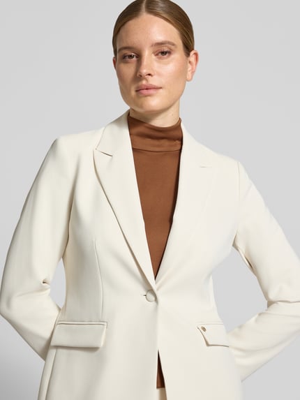 Frauenmodel trägt Regular Fit Blazer mit Reverskragen Modell 'Leonora' von MOS MOSH in Creme, Knopfverschluss, Nahaufnahme Oberkörper.