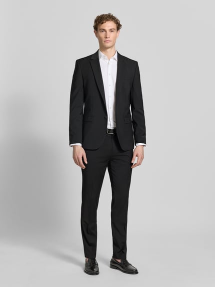 Männermodel trägt Super Slim Fit Anzug aus Woll-Mix Modell 'ARTI/HESTEN' von HUGO, Farbe Schwarz, Optik: Unifarben, Ganzkörperansicht von vorne.