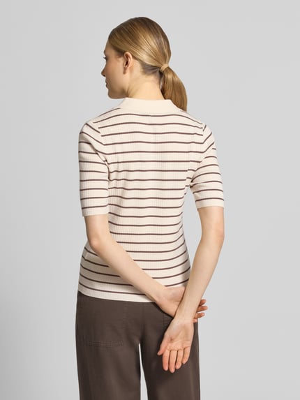 Frauenmodel trägt Strickshirt mit Streifenmuster Modell 'Caliz' von MOS MOSH, cremefarben-braun, Ripp-Optik, Ganzkörperansicht Rückansicht. Damen Strickshirt aus Viskose-Mix mit Seiden-Anteil, Regular Fit, Polokragen und Knopfleiste, Rückenlänge 54 cm, Ärmellänge 26 cm.