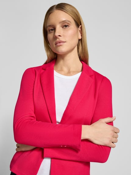 Vrouwenmodel draagt Regular Fit Kurzblazer met katoen-aandeel Model 'JULIA' van Vero Moda, look: effen, piqué materiaal, reverskraag, 1-knoopssluiting, lange mouw met kissing buttons, klepzakken, nahaufnahme bovenlichaam.