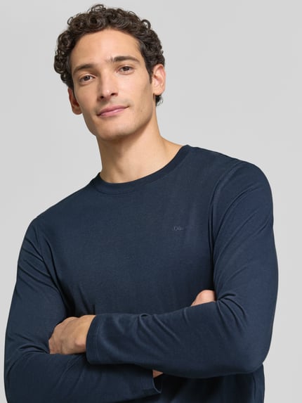 Männermodel trägt ein unifarbenes, dunkelblaues Langarmshirt mit Rundhalsausschnitt von S.OLIVER CASUAL, Nahaufnahme Oberkörper.