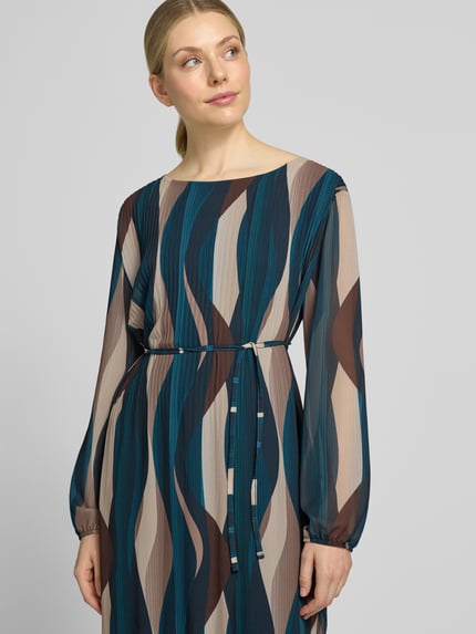Frauenmodel trägt knielanges Kleid mit Bindegürtel Modell 'Sa44raa' von ZABAIONE aus Chiffon in Blau-Braun mit Plisseefalten, Nahaufnahme Oberkörper.