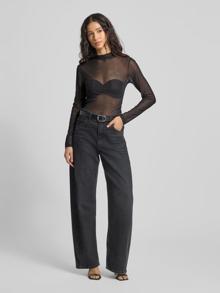 Frauenmodel trägt Longsleeve mit Stehkragen von Rich & Royal, schwarzer Material-Mix mit Stretch-Anteil, Slim Fit, semitransparent, Ganzkörperansicht von vorne.