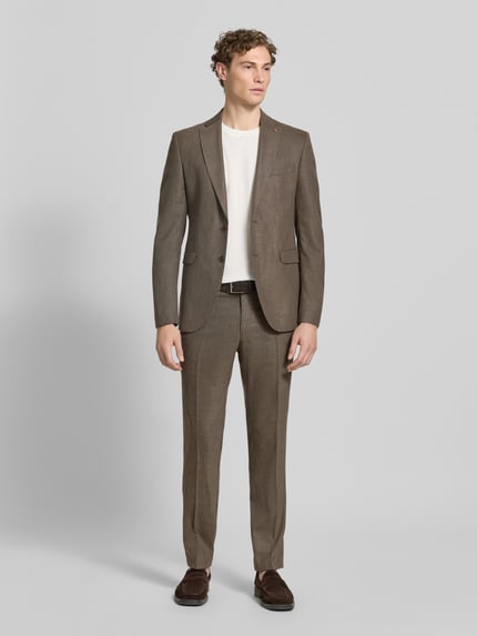 Männermodel trägt Slim Fit Stoffhose mit Woll-Anteil Modell 'Cole' von CG - Club of Gents in Braun, Elastischer-Material-Mix, Bügelfalten, Eingriffstaschen, Gesäßtasche, Knopf- und Reißverschluss, Ganzkörperansicht von vorne.