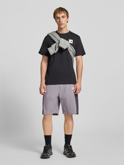 Männermodel trägt Shorts mit Logo und Gürtel von The North Face, zweifarbig, Regular-Fit, elastischer Bund, Ganzkörperansicht von vorne.