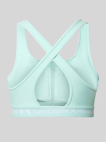 Vrouwenmodel draagt Slim Fit SportBH met Logoprint van Under Armour, elastische materiaalmix, cut-out op de rug, rugaanzicht.