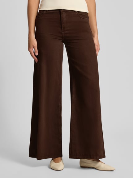Frauenmodel trägt Wide Fit Jeans mit Eingrifftaschen von REVIEW in Braun, reine Baumwolle, glatte Struktur, Ganzkörperansicht von vorne.