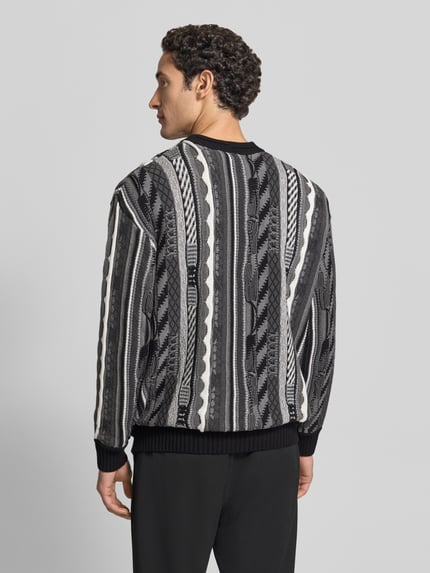 Männermodel trägt Regular Fit Strickpullover aus reiner Baumwolle von COLUCCI, schwarz-graumeliert, feine Strickstruktur, Ganzkörperansicht Rückansicht.