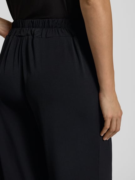 Frauenmodel trägt Stoffhose in verkürzter Passform Modell 'LIMA' von ICHI, Material-Mix mit Stretch-Anteil, Detailaufnahme Rückansicht.