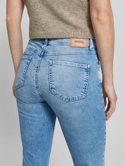 Frauenmodel trägt Slim Fit Jeans mit Strasssteinbesatz Modell 'Ornella Beauty' von Angels, hellblauer Baumwoll-Mix, 5-Pocket-Design, Strukturoptik, Körpernaher-Schnitt, Knopf-Reißverschluss, Bundweite 38 cm, Innenbeinlänge 67 cm, Ganzkörperansicht Rückansicht.